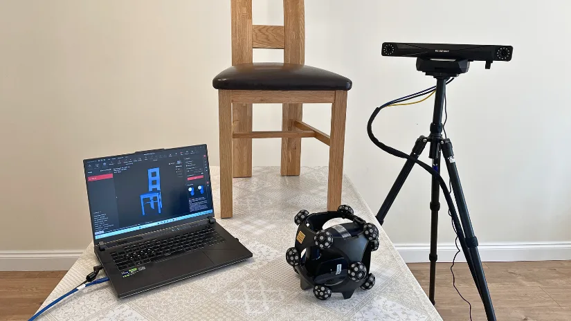 Revopoint Trackit SR setup scanning a wooden chair with the scanner, optical tracker, and laptop.