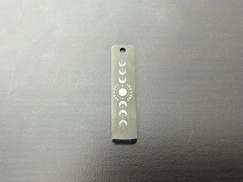 Anodized pendant with a moon-phase design engraved using the xTool M2