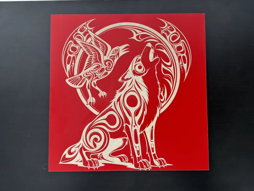 Raven and wolf design engraved into red MDF with a contrasting pale core